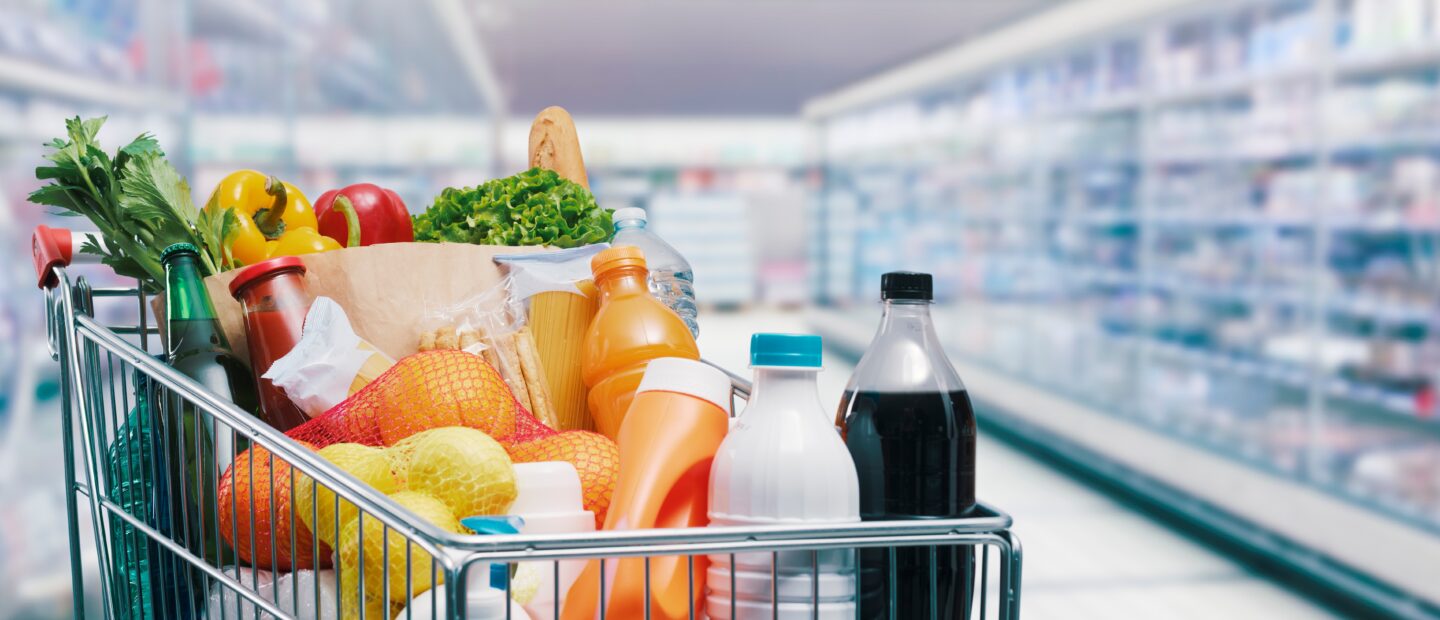 Shopping,Cart,Filled,With,Food,And,Drinks,And,Supermarket,Shelves